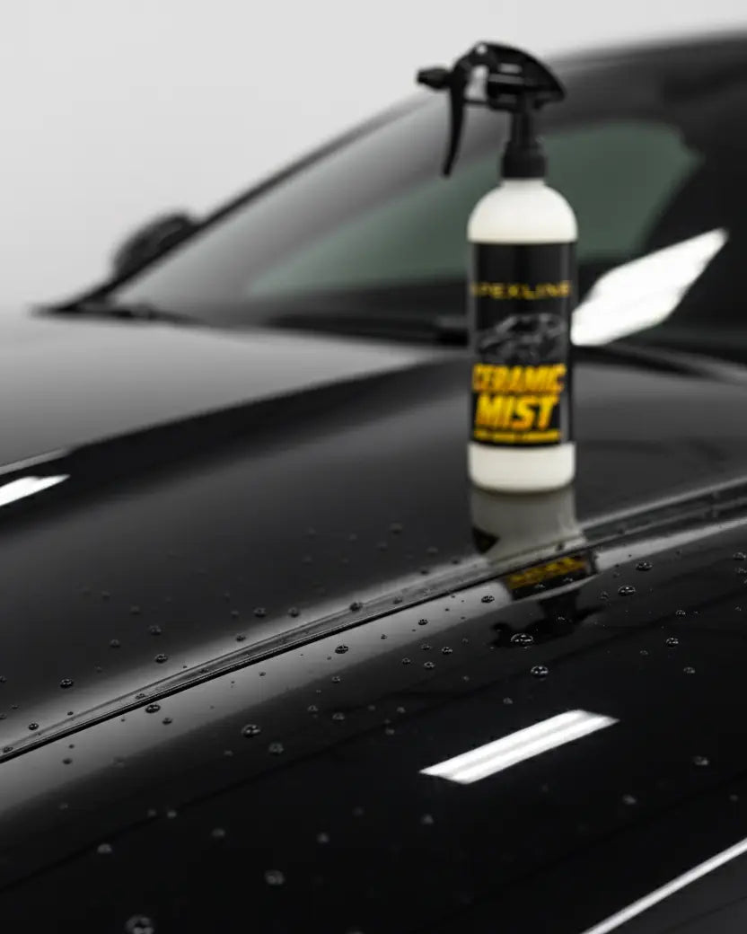 Foto producto con fondo de capó de coche de lujo con producto difuminado al fondo, caramic mist cera líquida de carnauba marca apexline letras en dorado y etiqueta negra, producto color blanco