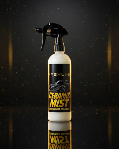 Foto producto con fondo negro con luz dorada ambiental, caramic mist cera líquida de carnauba marca apexline letras en dorado y etiqueta negra, producto color blanco