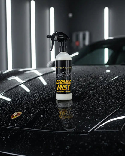 Foto producto con fondo de capó de coche de lujo negro mojado, caramic mist cera líquida de carnauba marca apexline letras en dorado y etiqueta negra, producto color blanco
